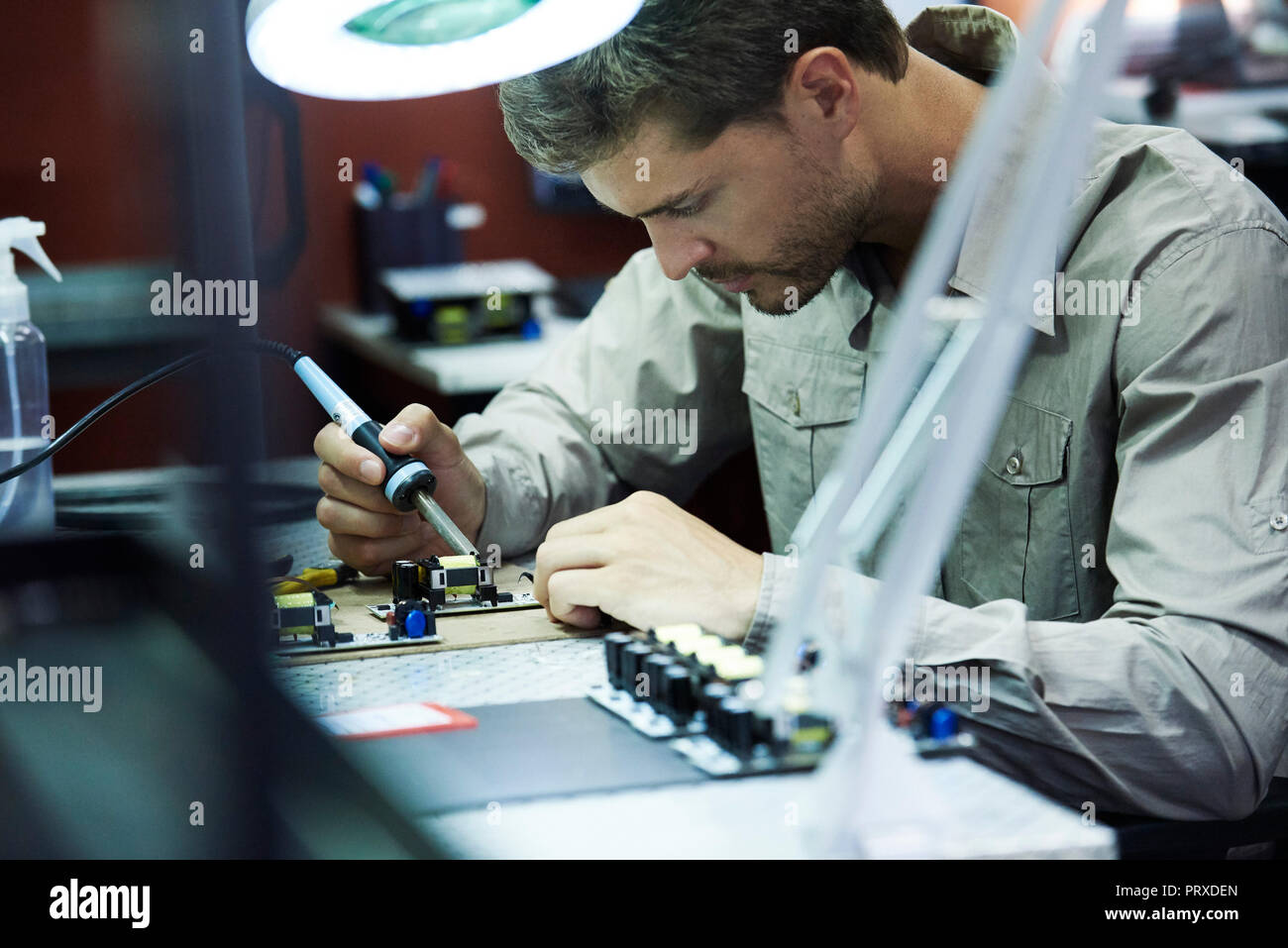 Engineer soldering circuit board in office Stock Photo Alamy