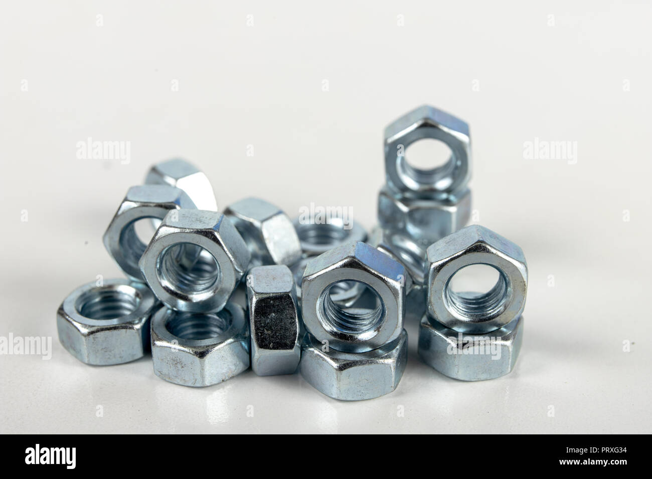 Chrome caps on a white table. Accessories for mounting steel structures on a workshop table. White background. Stock Photo