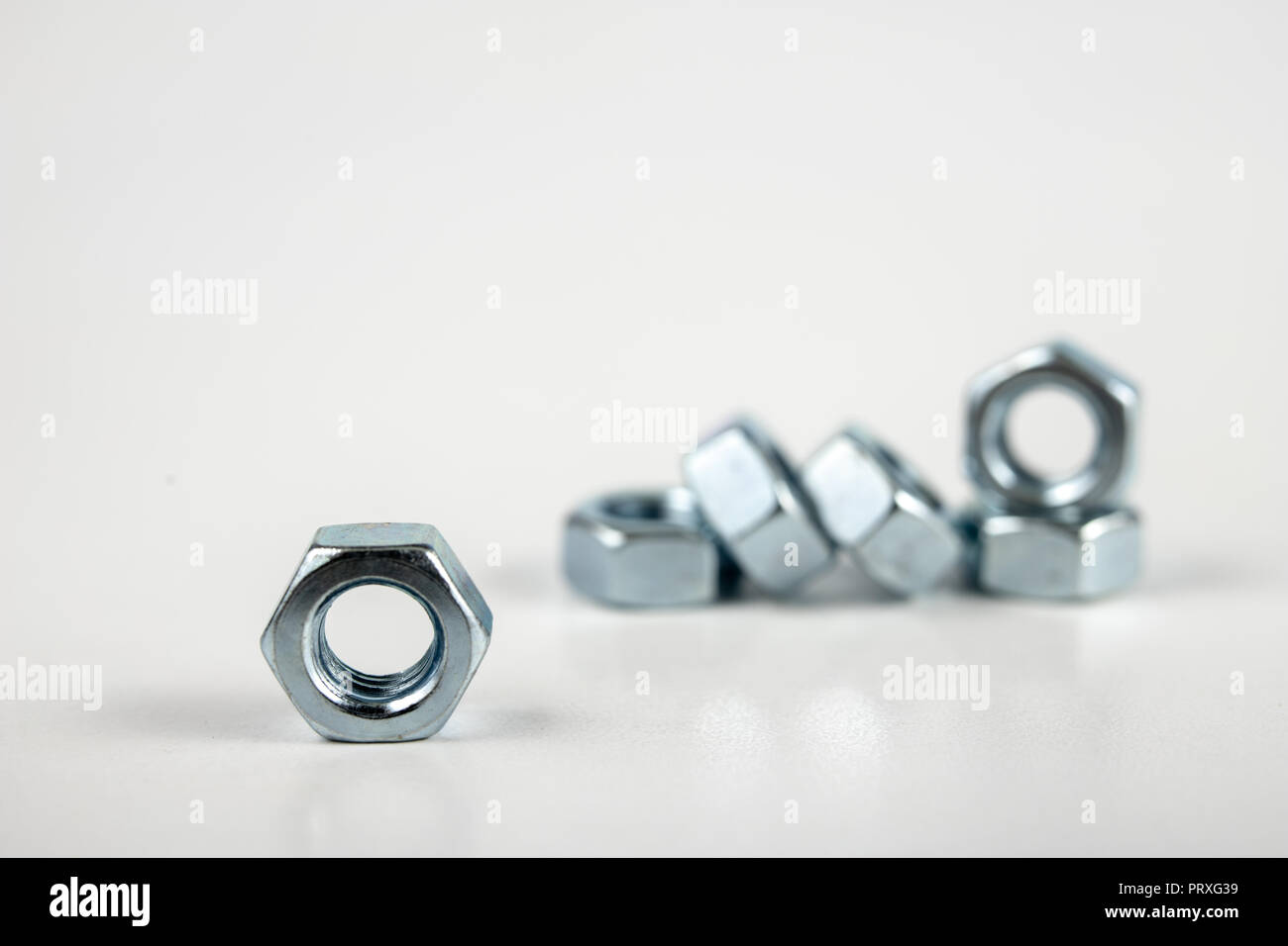 Chrome caps on a white table. Accessories for mounting steel structures on a workshop table. White background. Stock Photo