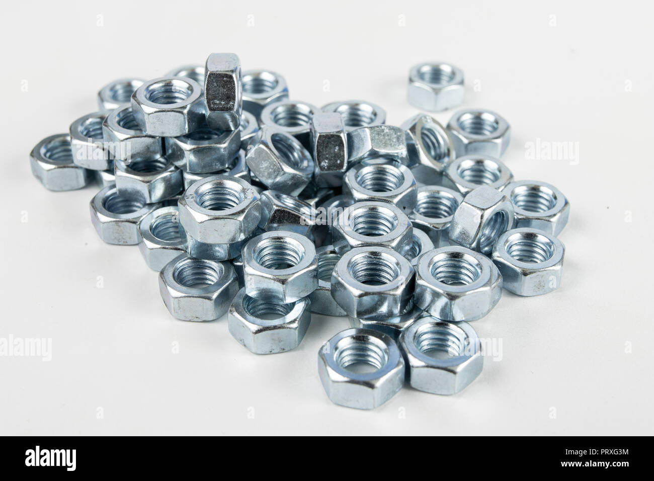 Chrome caps on a white table. Accessories for mounting steel structures on a workshop table. White background. Stock Photo
