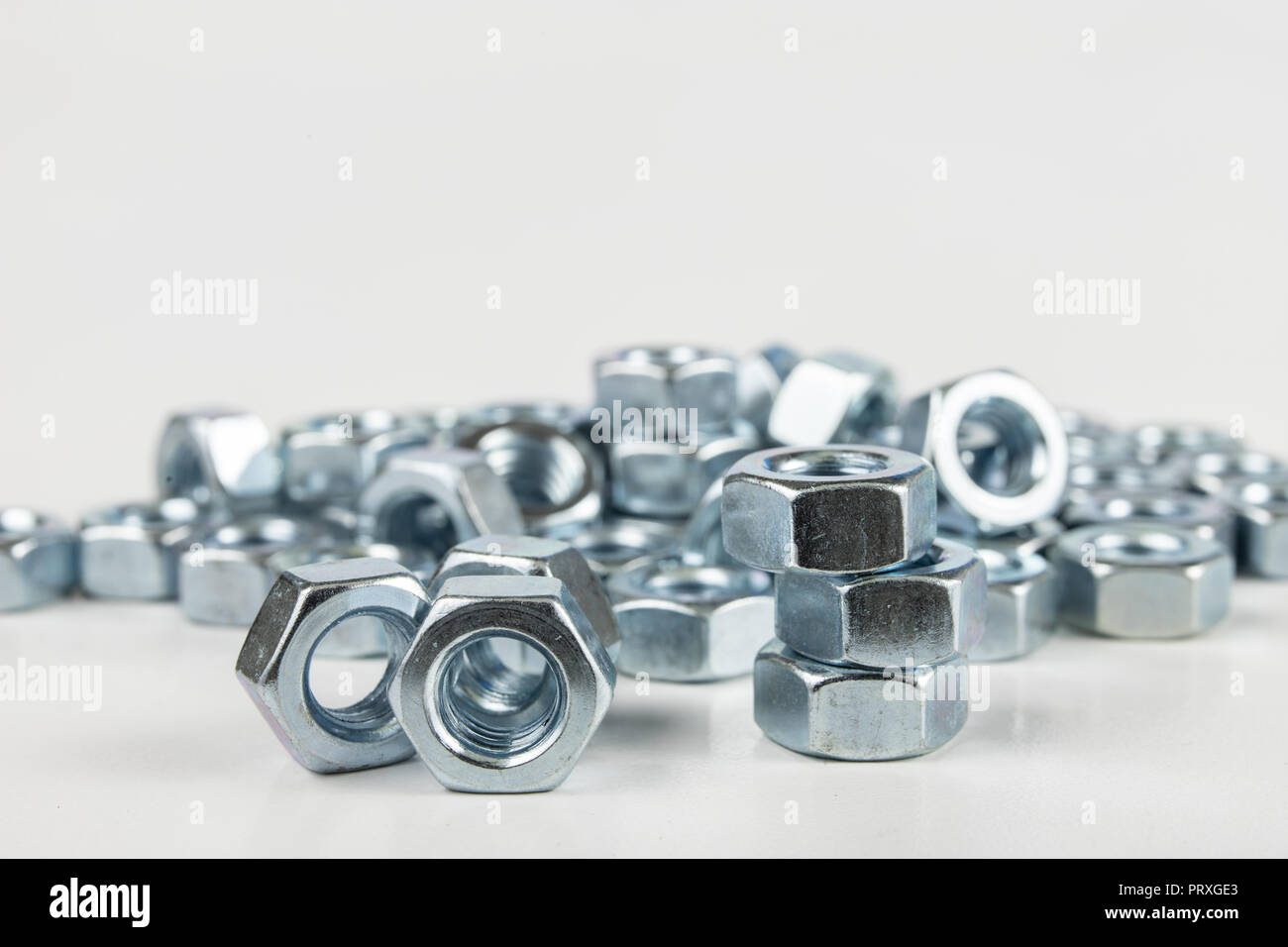 Chrome caps on a white table. Accessories for mounting steel structures on a workshop table. White background. Stock Photo