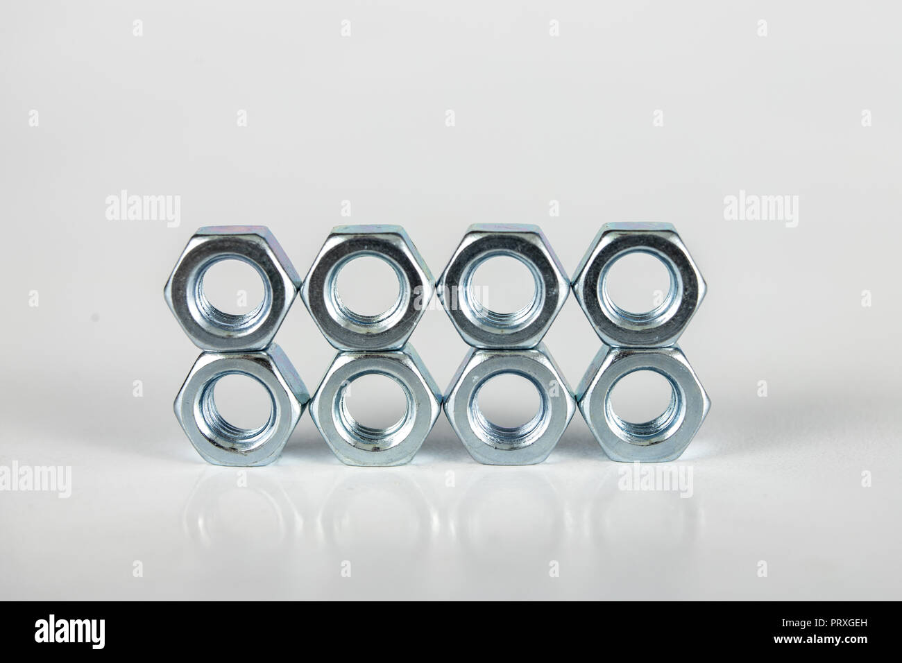 Chrome caps on a white table. Accessories for mounting steel structures on a workshop table. White background. Stock Photo