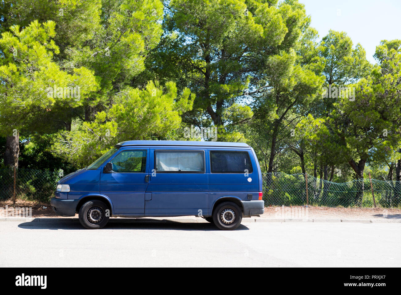A blue van parked on the road side on the sunshine Stock Photo - Alamy