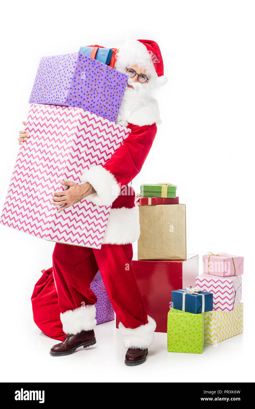 santa claus in eyeglasses holding pile of gift boxes isolated on white ...