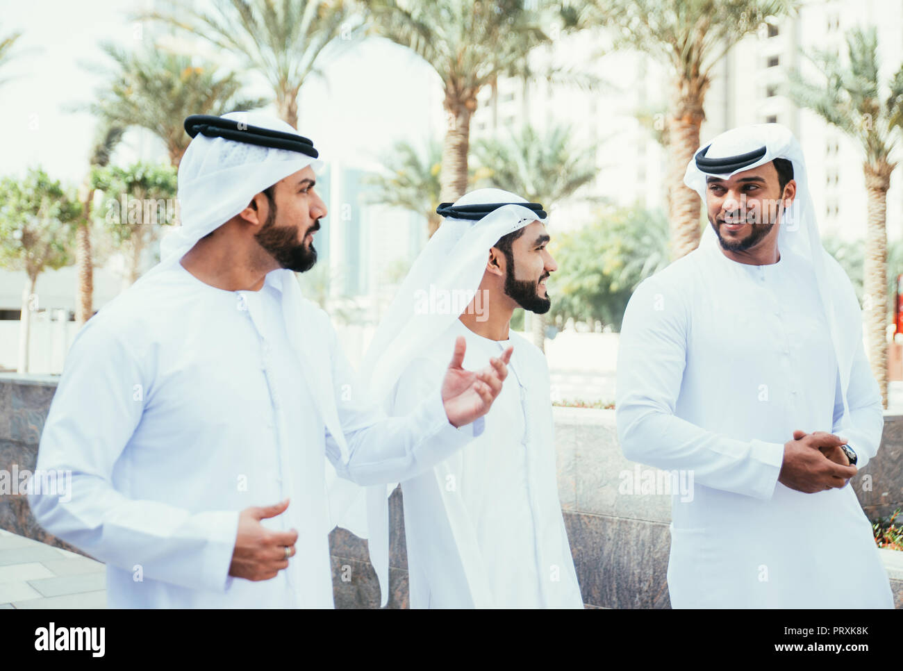 Group of businessmen talking on the street in Dubai Stock Photo - Alamy