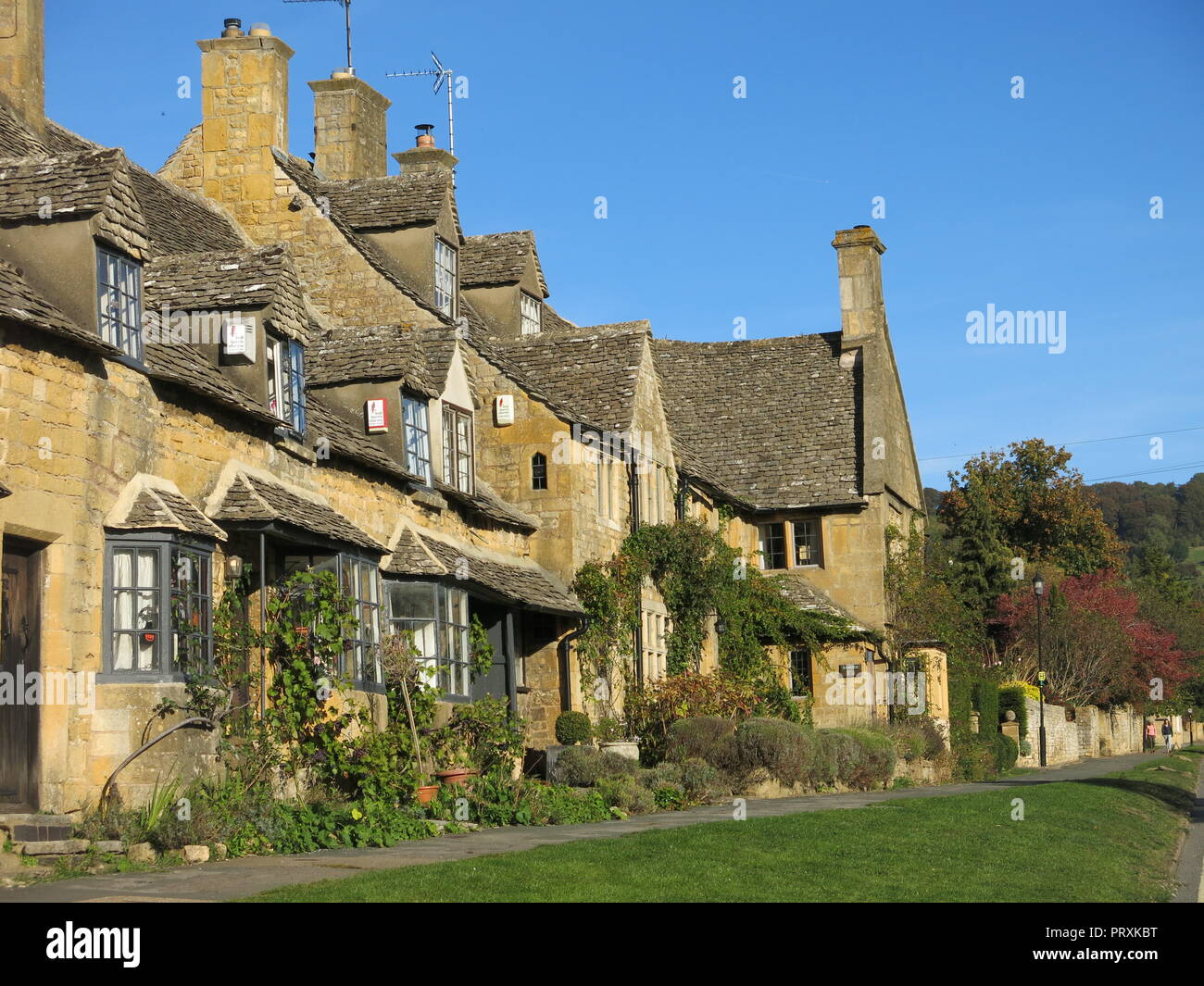 A row of honeycoloured Cotswold stone cottages in the autumn sunshine