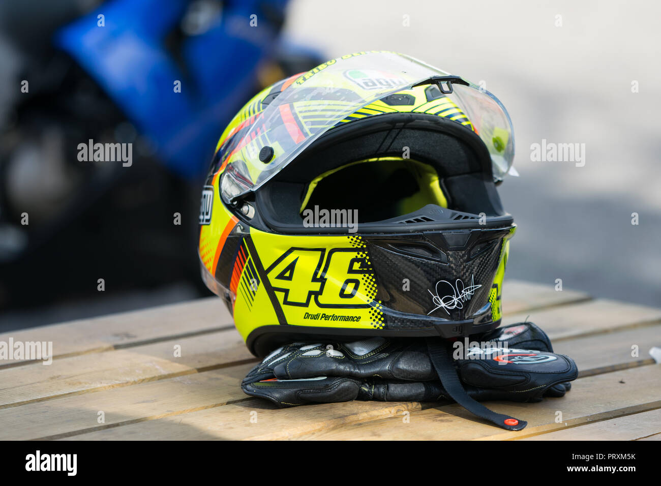 view on the table and helm on the AGV company with painting number 46 in yellow color, underneath Spidi motorcycle gloves Stock Photo