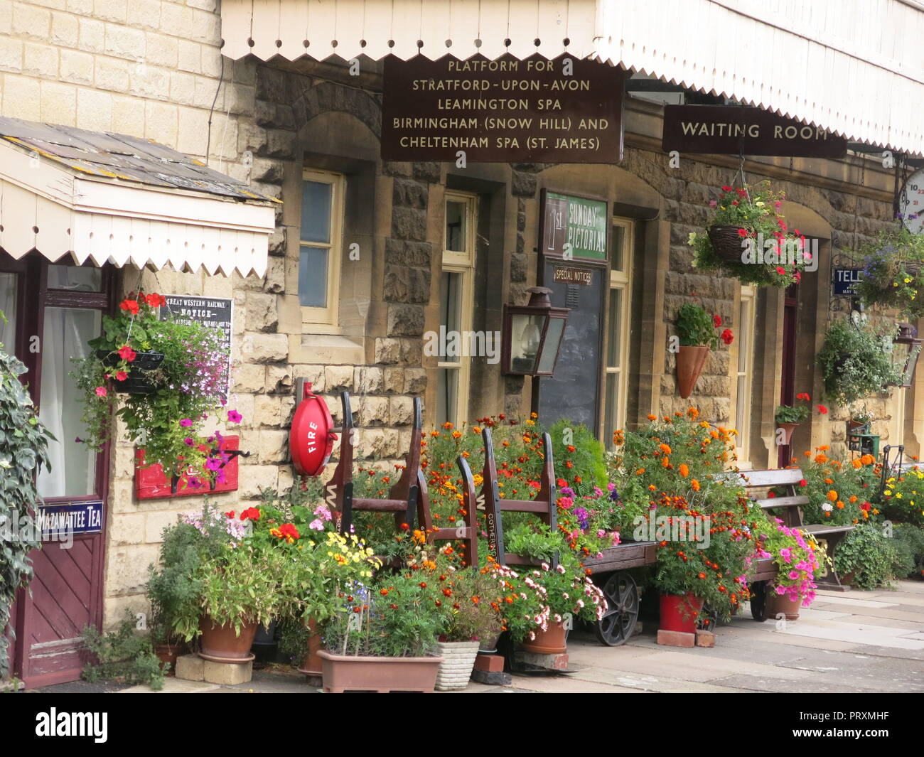 The platform & former station at Gotherington is adorned with colourful pots of flowers & hanging baskets: Gloucestershire Warwickshire Steam Railway Stock Photo
