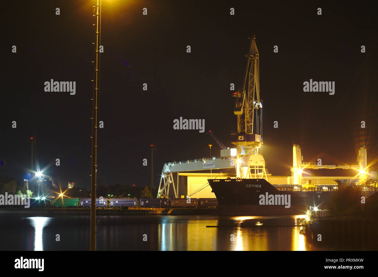 Big ship vessel while loading bulk in Bremen port with crane while night Stock Photo