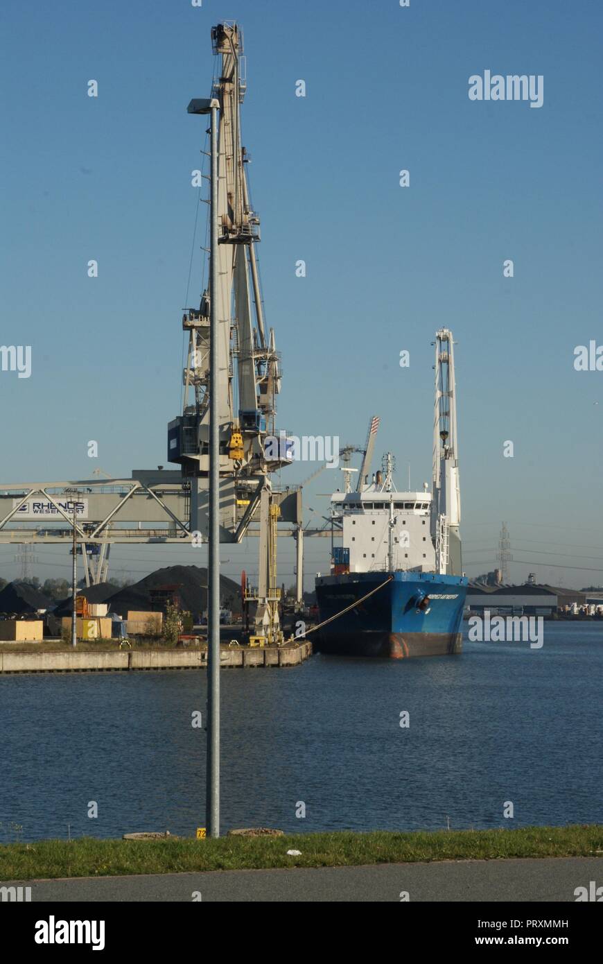 Big ship vessel while loading bulk in Bremen port with crane Stock Photo