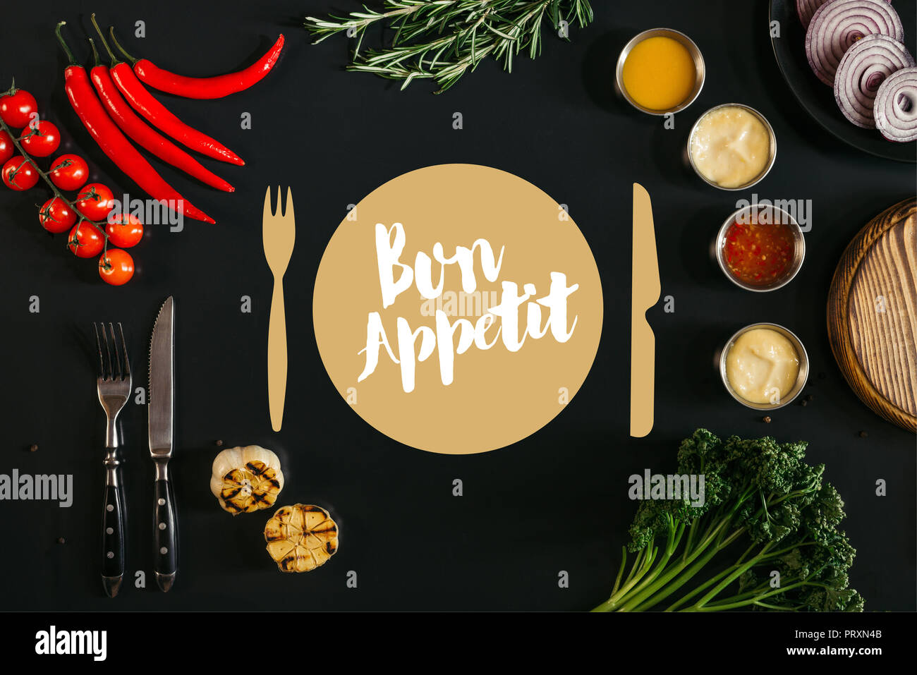 top view of various sauces, grilled garlic, fork with knife and fresh