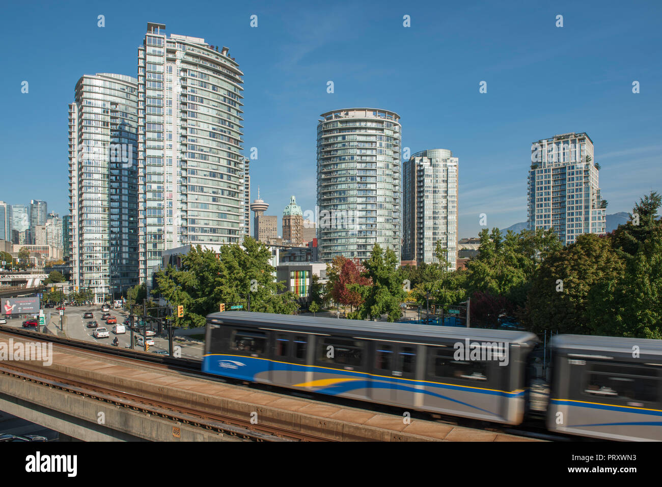 Skytrain moving along the tracks with the city of Vancouver as a backdrop, Stock Photo