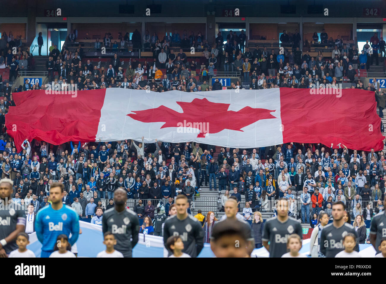 Large Canadian Flag being displayed by fans at a MLS soccer game, BC Place Stadium, Vancouver City. Stock Photo