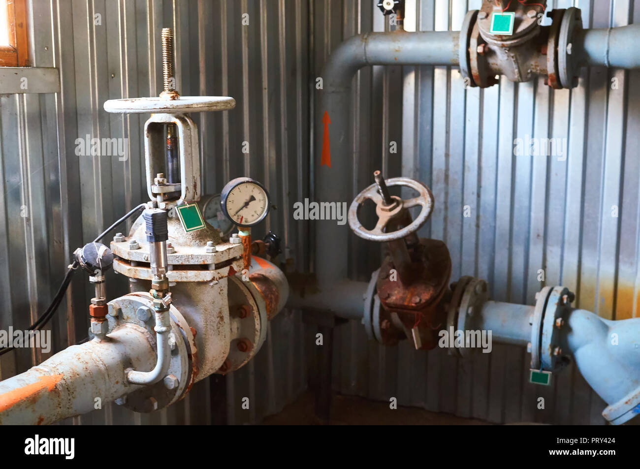 Several old valves on the cold water pipeline. Industrial background. Stock Photo