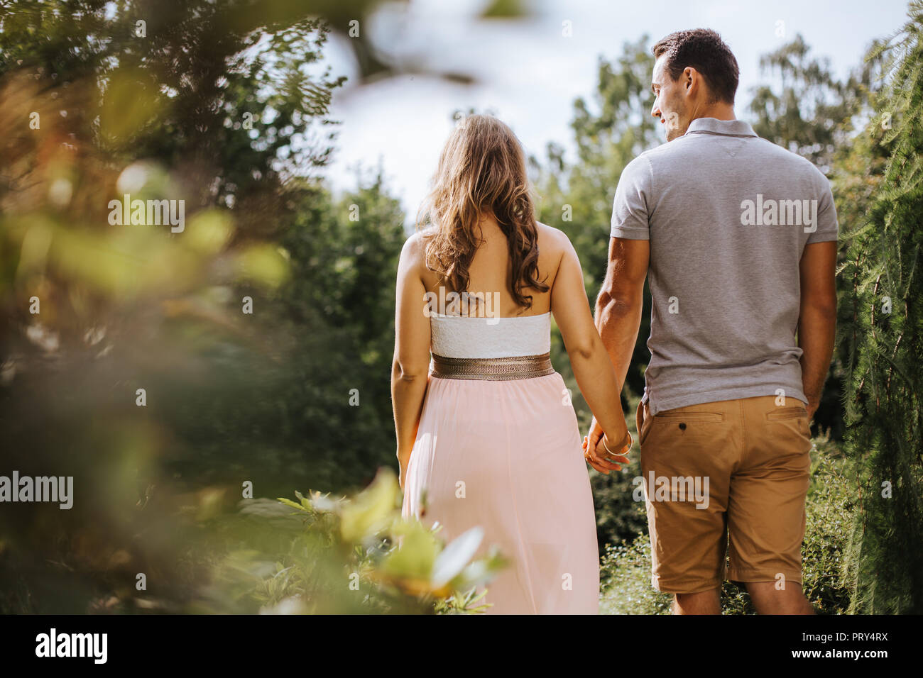 rear view of pregnant woman holding hands with her partner Stock Photo