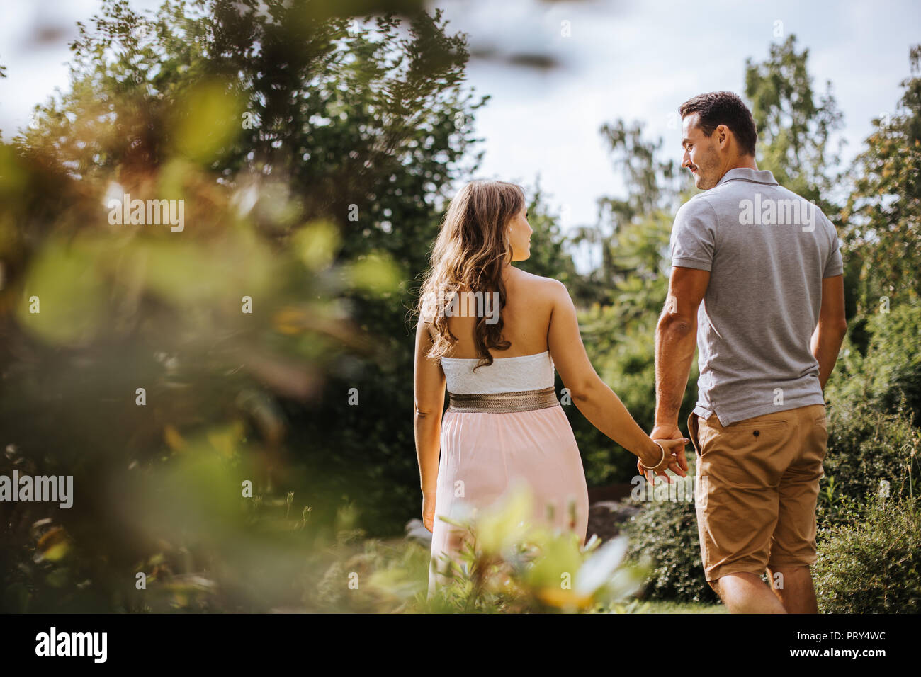 rear view of pregnant woman holding hands with her partner Stock Photo