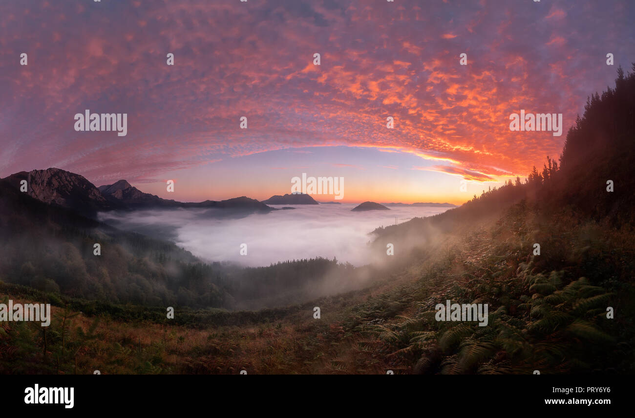 Colorful sunrise over Aramaiona valley under the fog in Alava Stock Photo