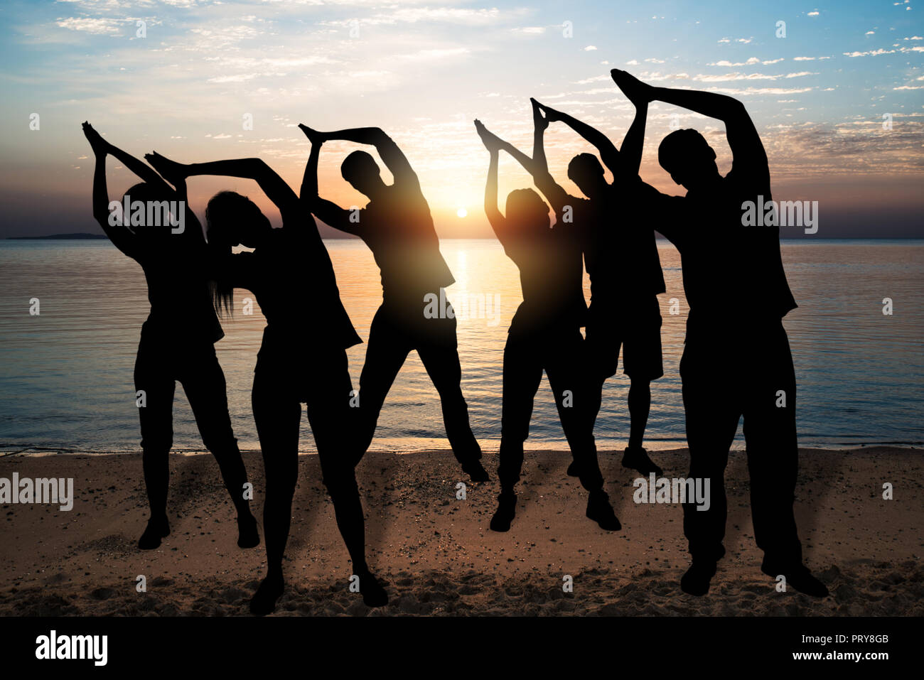 Silhouette Of People Doing Yoga In Park At Sunset Stock Photo - Alamy