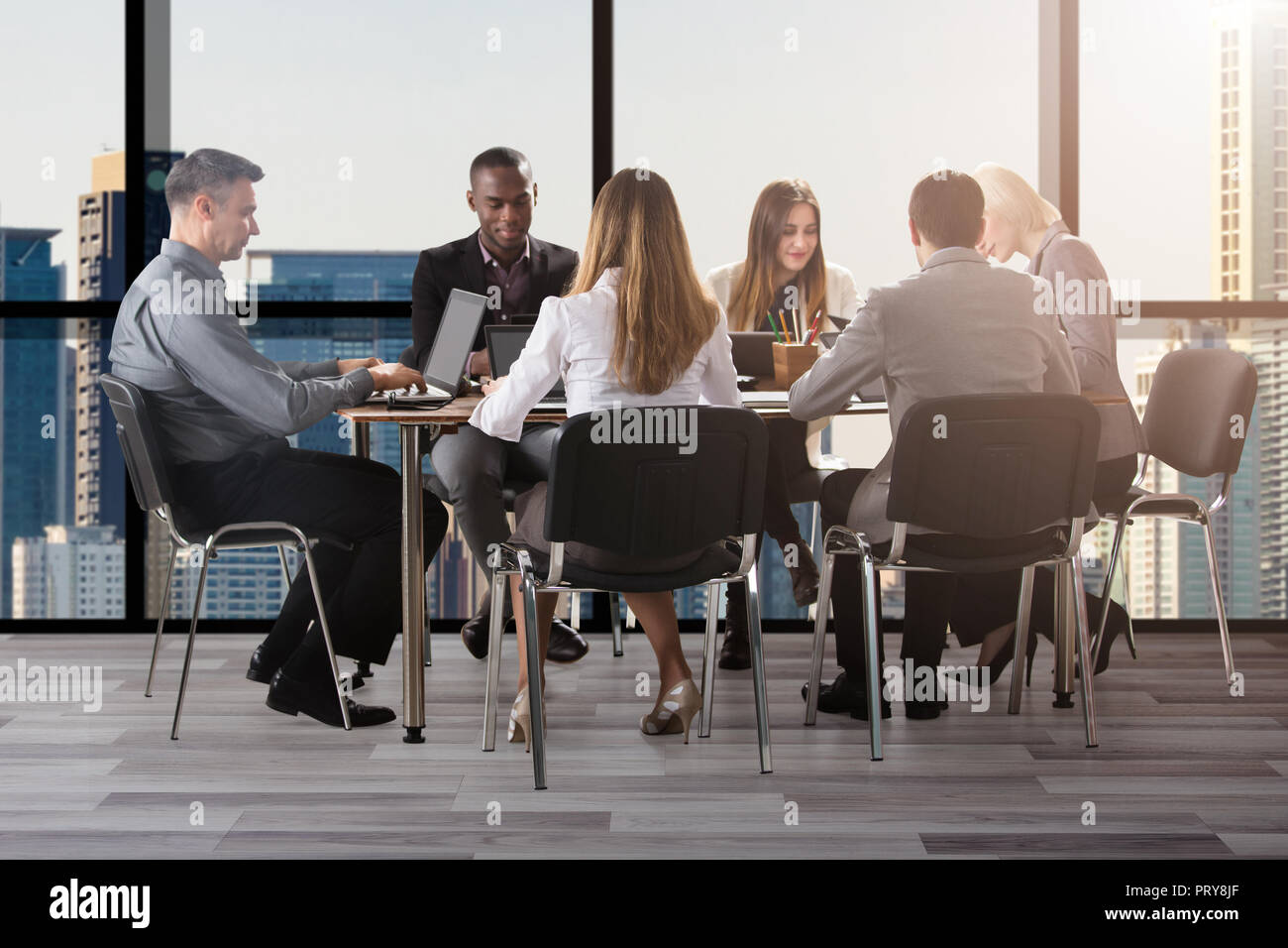 Group Of Diverse Businesspeople Sitting In Office During Business ...