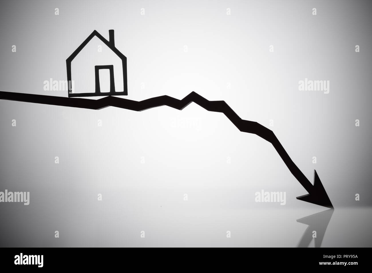 Outline Of A House On Arrow Moving In Downward Direction On Reflective Background Stock Photo
