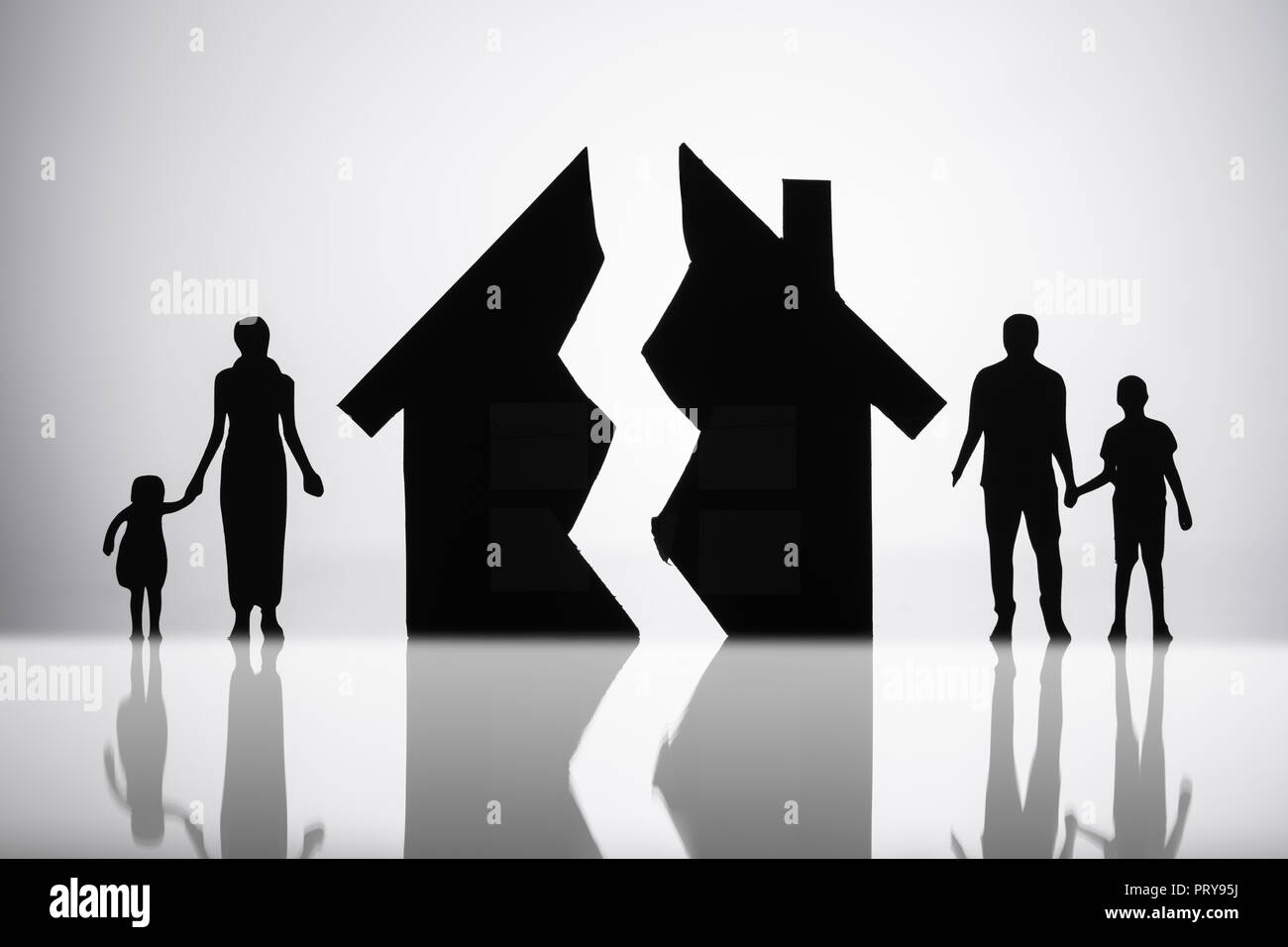 Separation Of Family With Broken House On Reflective Background Stock Photo