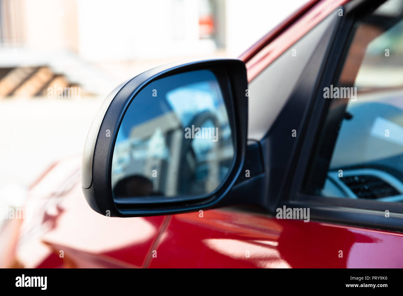 Rear View Mirror Of A Car Driving On Street Stock Photo