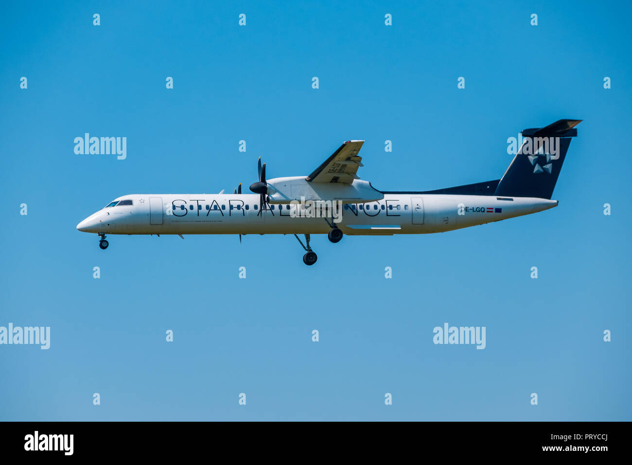 Star alliance airlines Bomardier Dash 8 Q400 airplane preparing for landing at day time in international airport Stock Photo