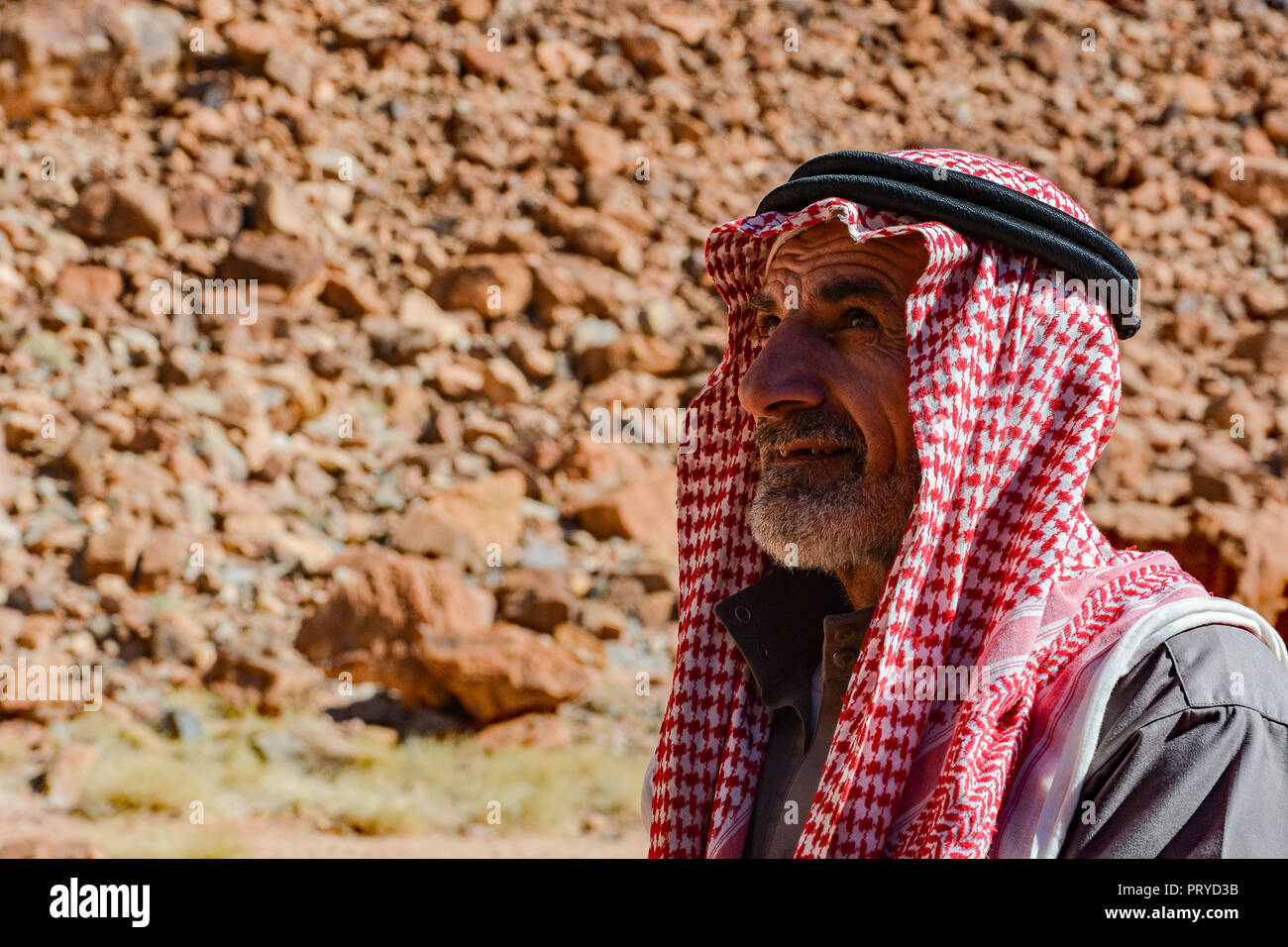 A Wadi Rum Bedouin posing for a photo in the desert. Photo taken at an encampment in the desert outside the village of Wadi Rum. Stock Photo