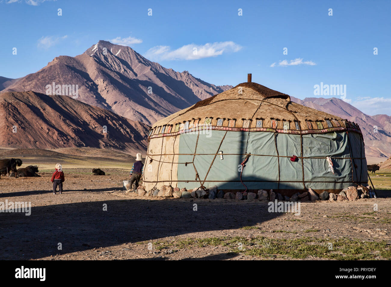 2 young Kyrgyz boys stand next to yurt during golden hour in the remote Pshart Valley in the Pamirs, Gorno-Badakhshan Autonomous Region, Tajikistan. Stock Photo