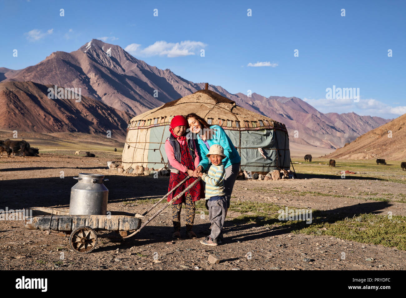 Trekker mingling with local Kyrgyz nomadic life in the remote Pshart Valley in the Pamir Mountains, Gorno-Badakhshan Autonomous Region, Tajikistan. Stock Photo