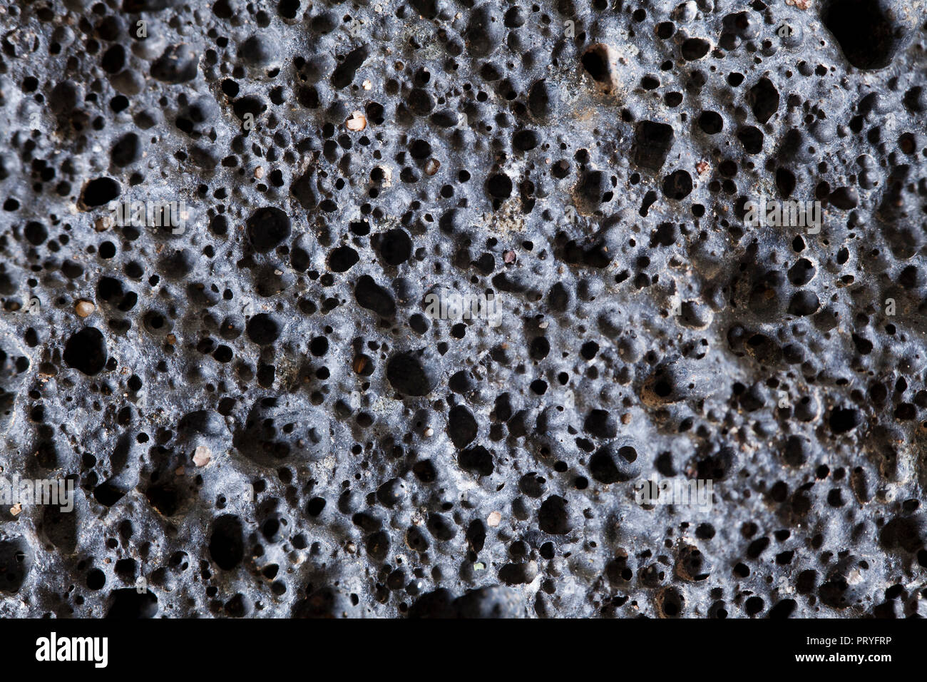 Close up of igneous rock (scoria, volcanic rock, lava rock - macro) showing vesicles, found in the Mojave desert, California - USA Stock Photo