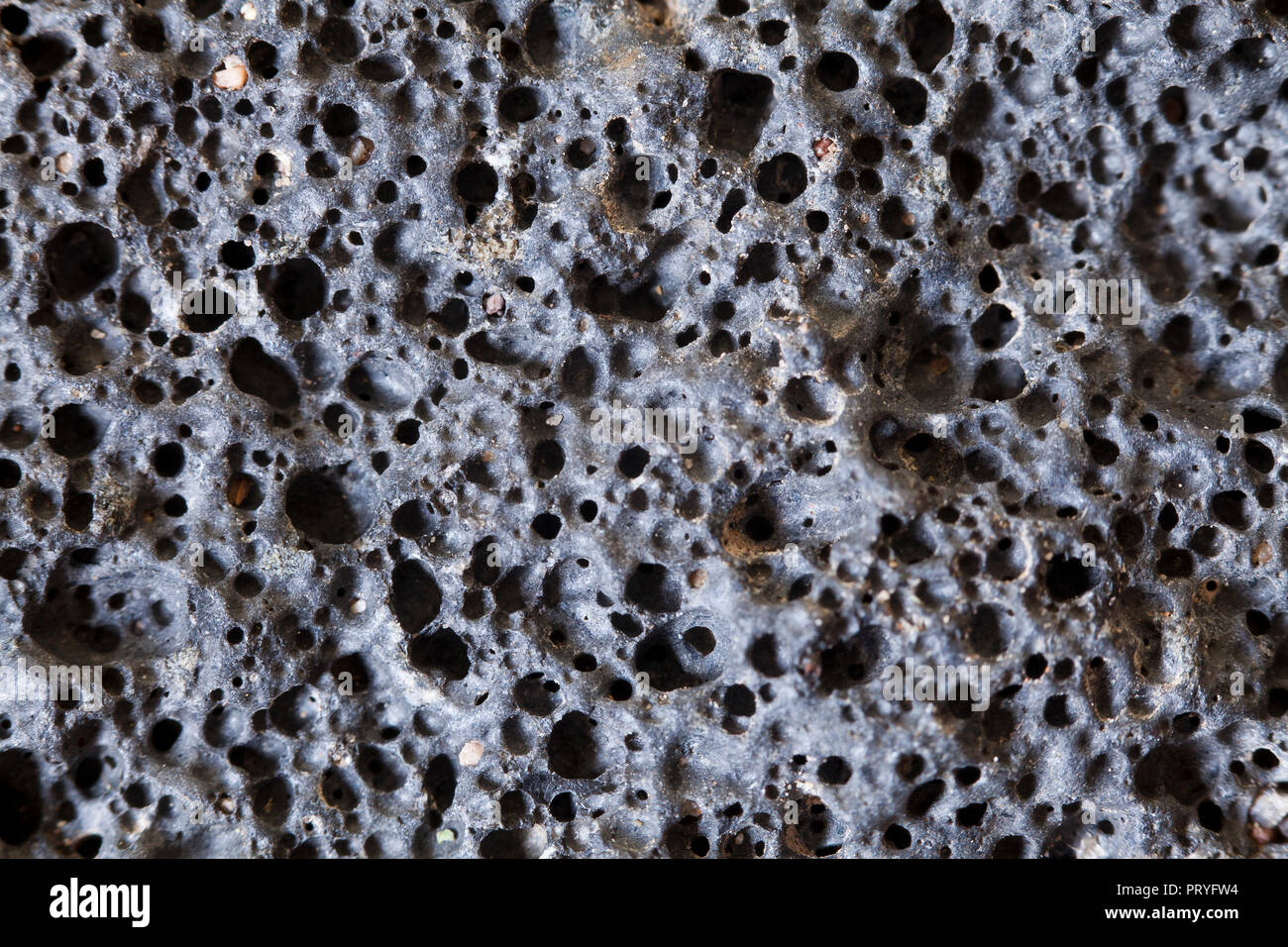 Close up of igneous rock (scoria, volcanic rock, lava rock - macro) showing vesicles, found in the Mojave desert, California - USA Stock Photo