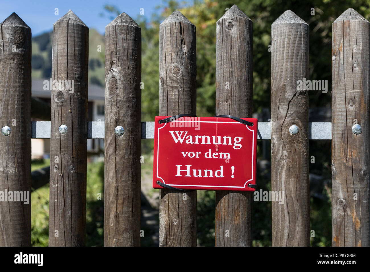 Red warning sign on garden fence, dog warning, Switzerland Stock Photo
