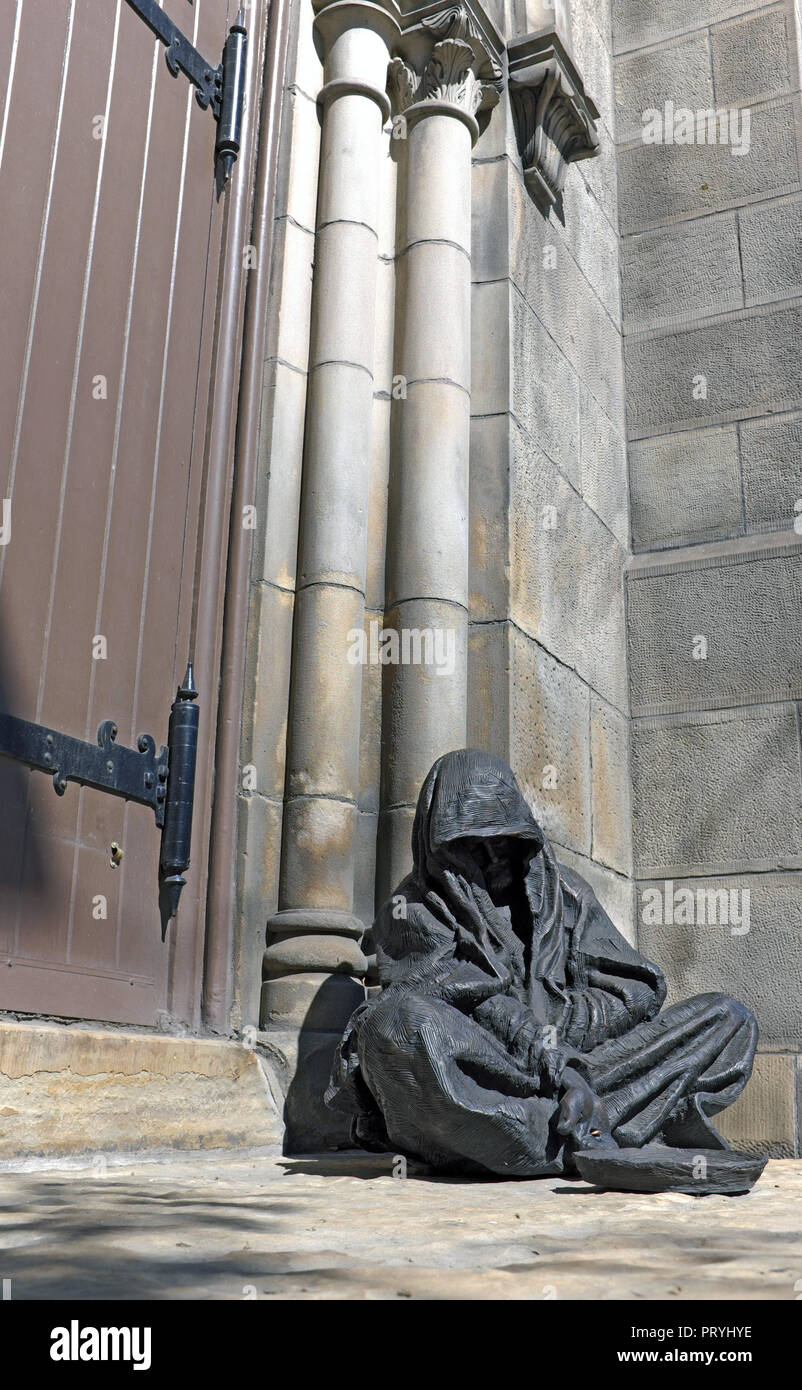 Jesus the beggar sculpture based on Matthew 25:40, created by Timothy Schmalz, sits outside the Old Stone Church in Cleveland, Ohio, USA. Stock Photo