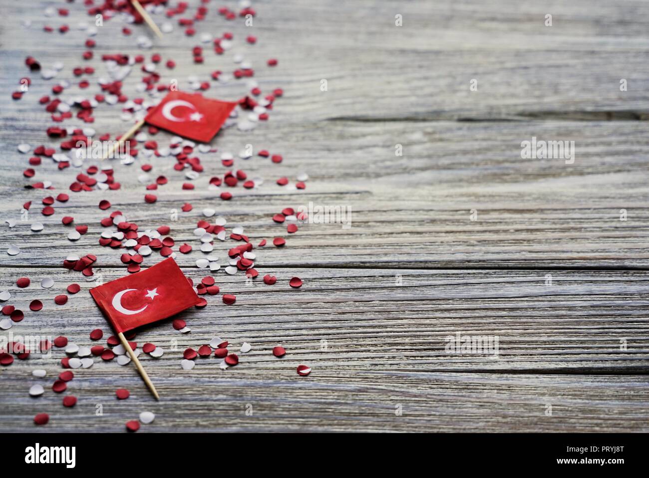 concept-independence day of Turkey, national paper flags of the state of Turkey with white red confetti on a white brushed wooden background, horizont Stock Photo