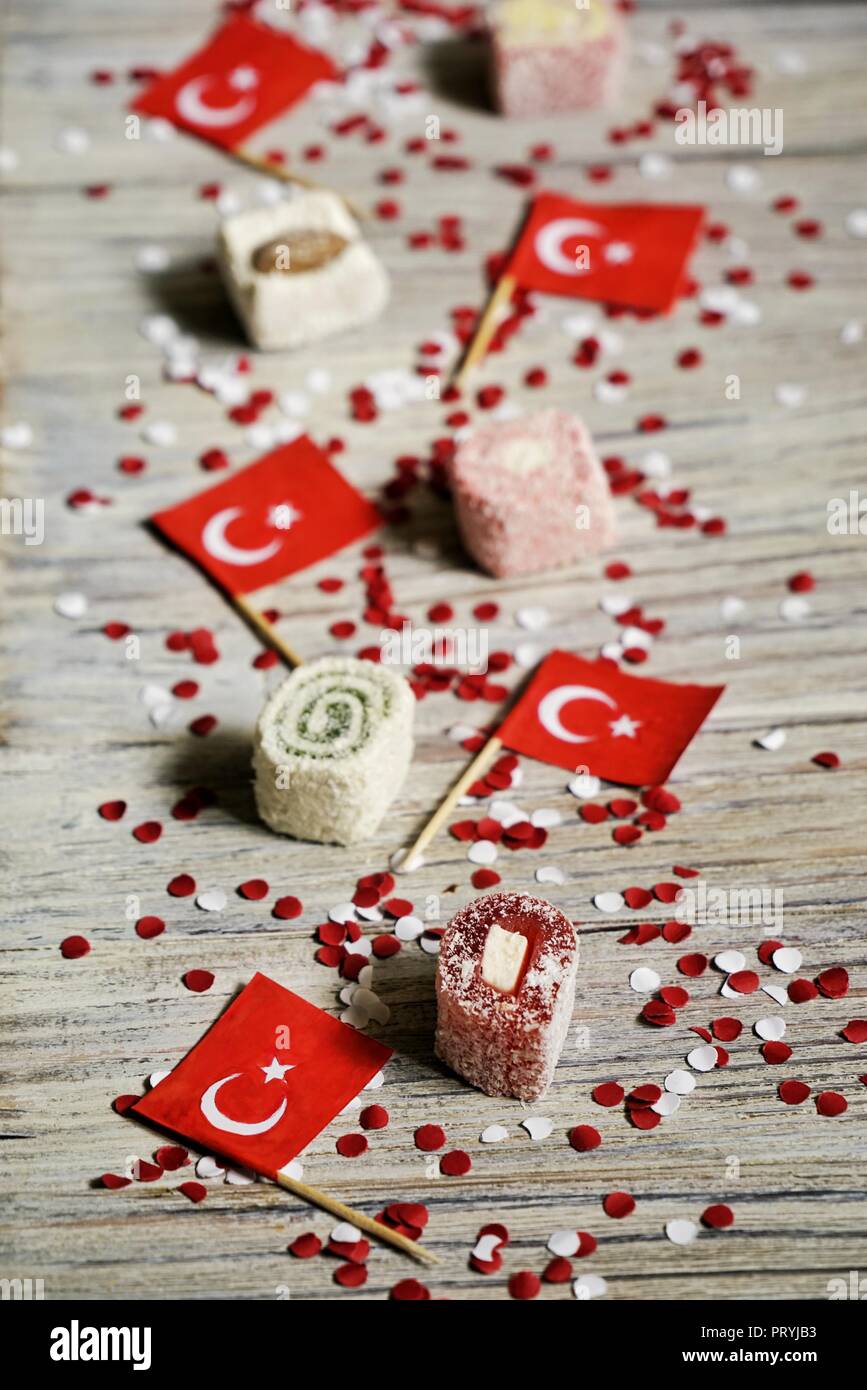 concept-independence day of Turkey, national paper flags of the state of Turkey with white red confetti on a white brushed wooden background, vertical Stock Photo