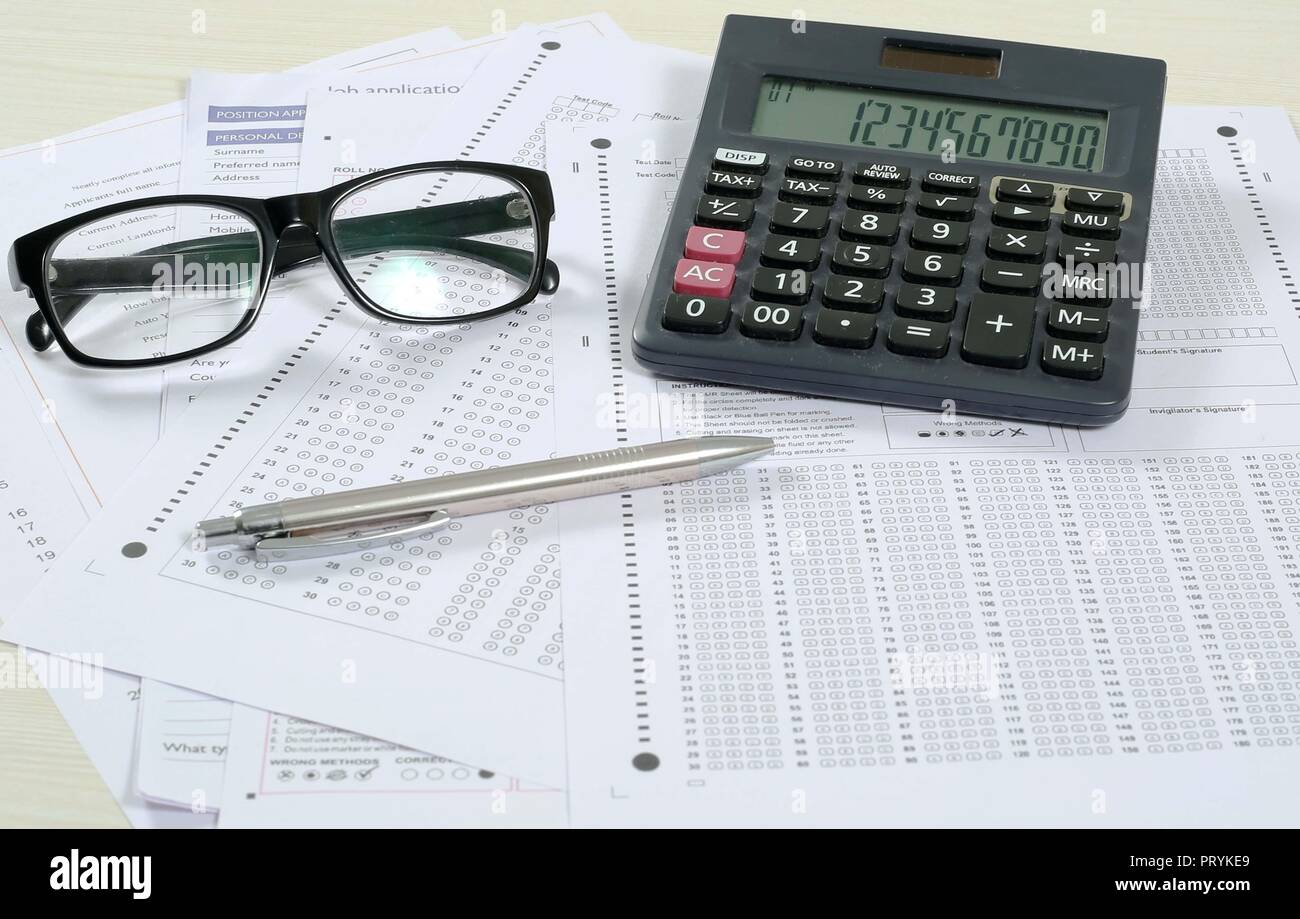 Picture of multiple omr sheet, pen, glasses and calculator. Isolated on white background. Stock Photo