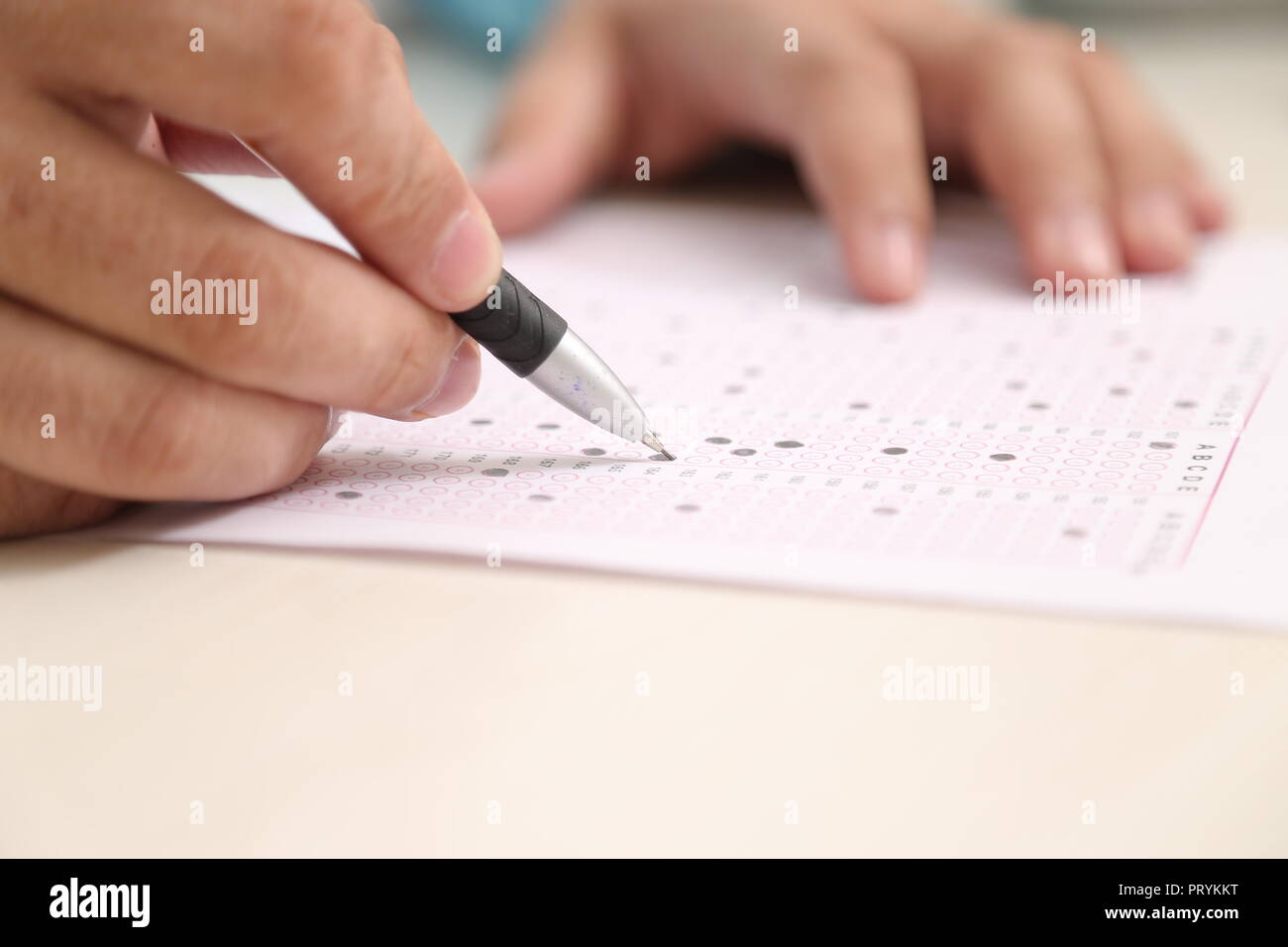 Picture of man is filling OMR sheet with pen Stock Photo Alamy