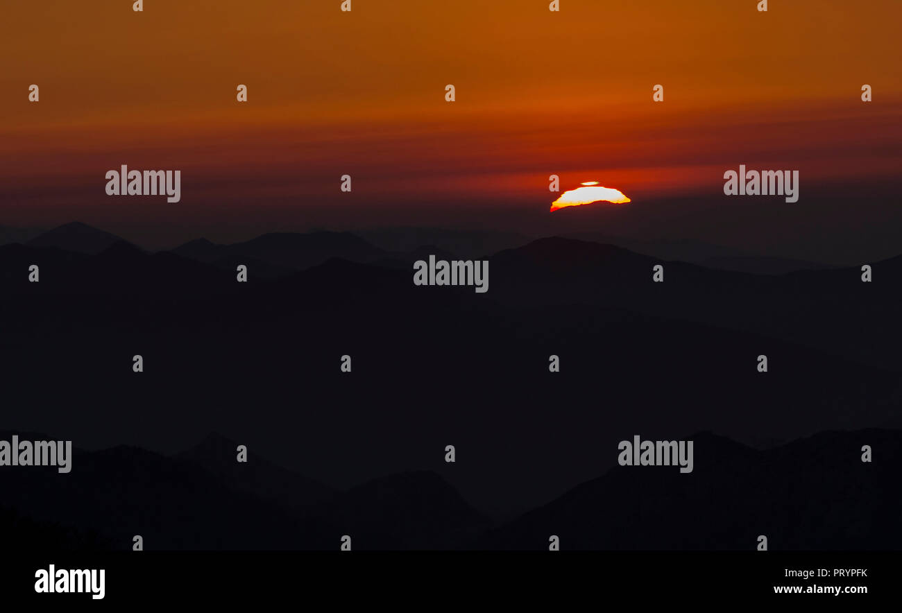Spain, Cantabria, setting sun behind mountains Stock Photo