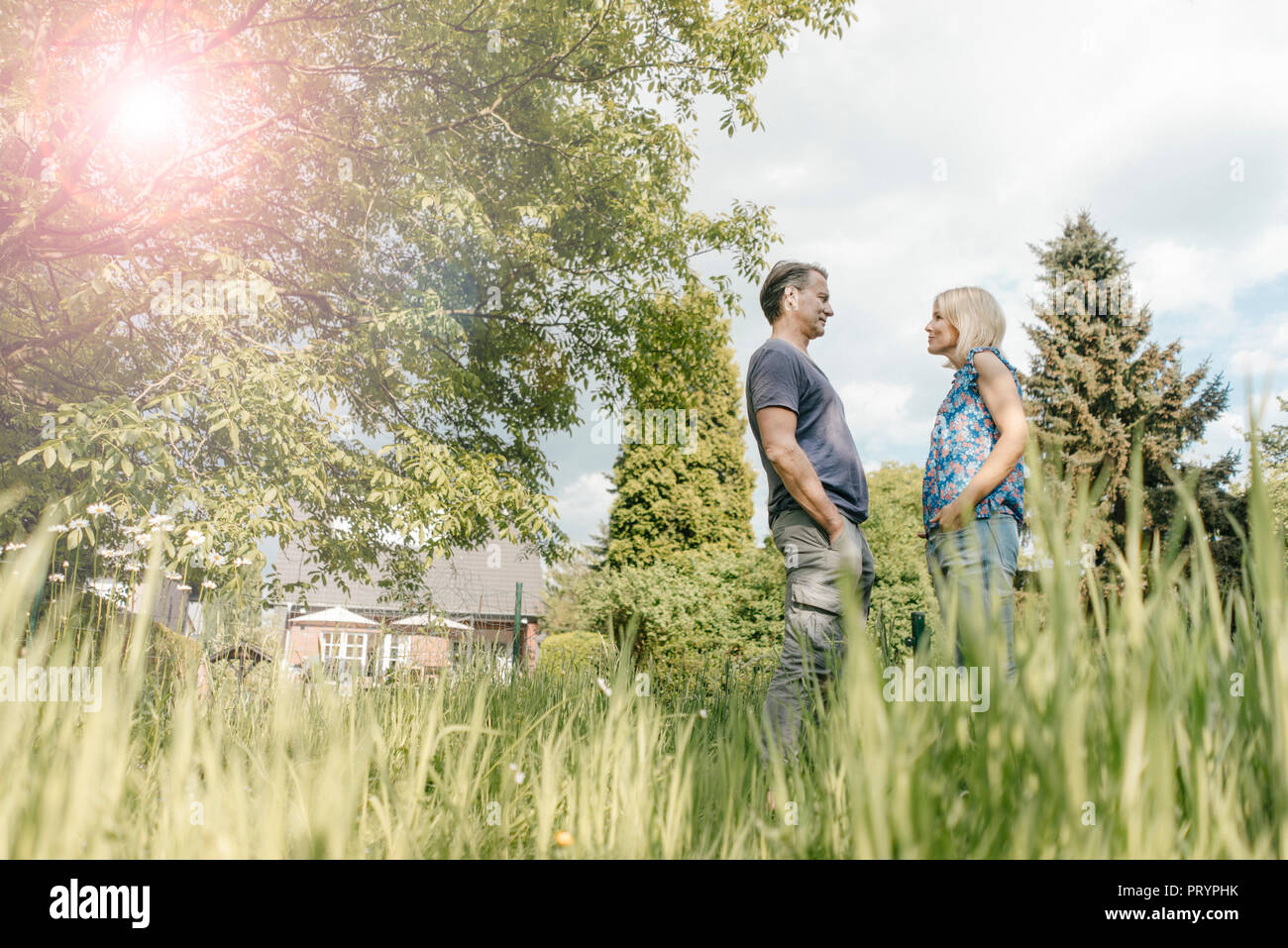 Mature couple standing face to face in garden of their home Stock Photo