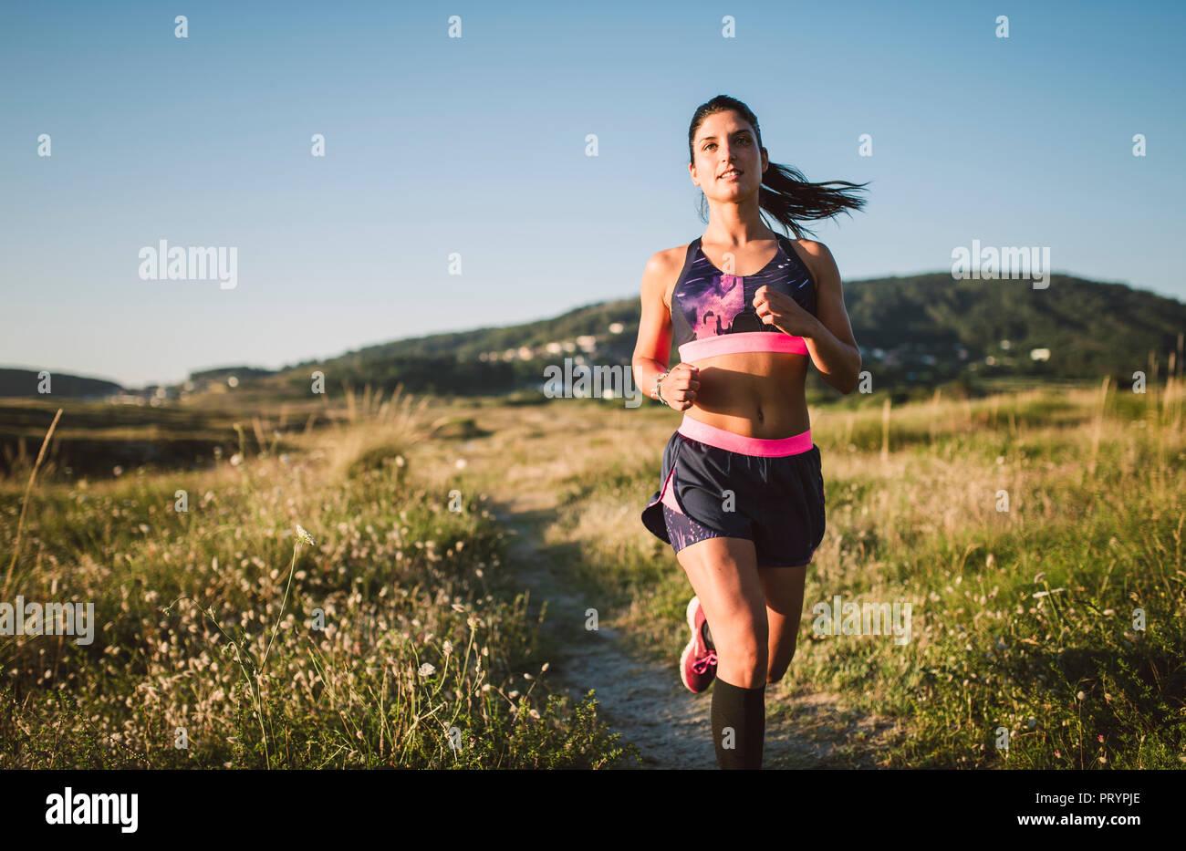 Sportswoman jogging on path Stock Photo