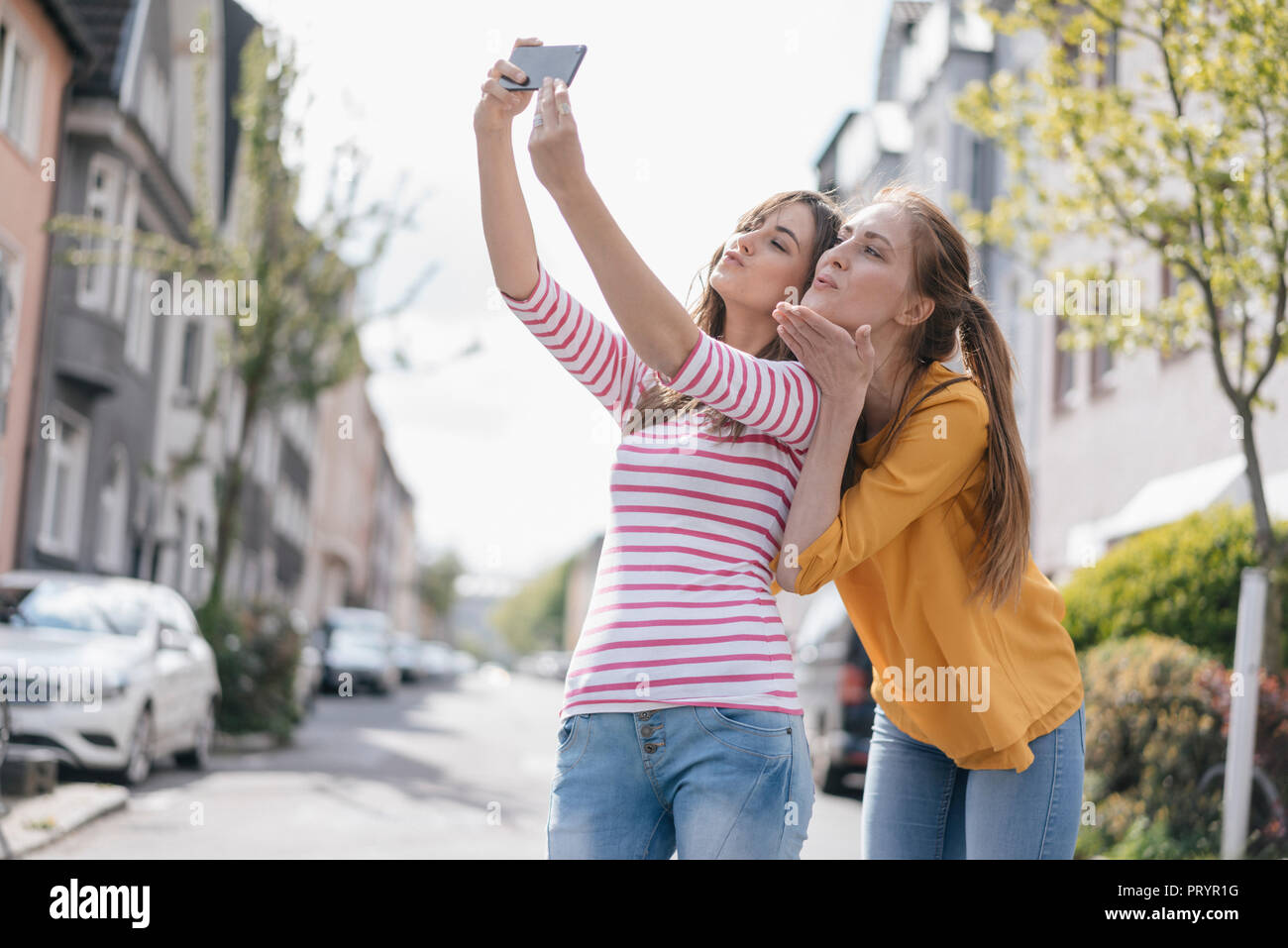 Girlfriends taking selfie in the city Stock Photo