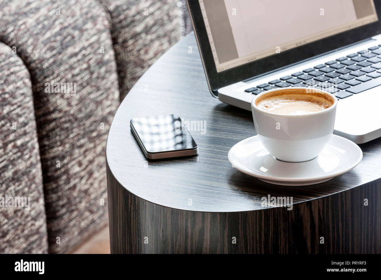 Poland, Warsaw, laptop, smartphone and coffee cup at lounge of hotel Stock Photo
