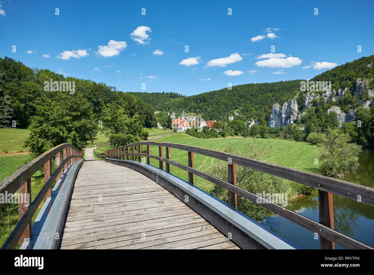 Germany, Baden-Wurttemberg, Sigmaringen district, Pedestrian bridge over Danube river with St.George's Basilica in background Stock Photo