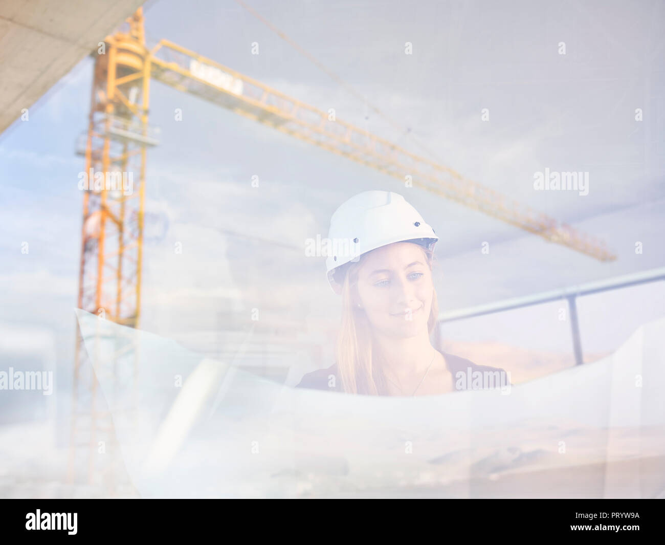 Female architect on construction site checking blueprint Stock Photo