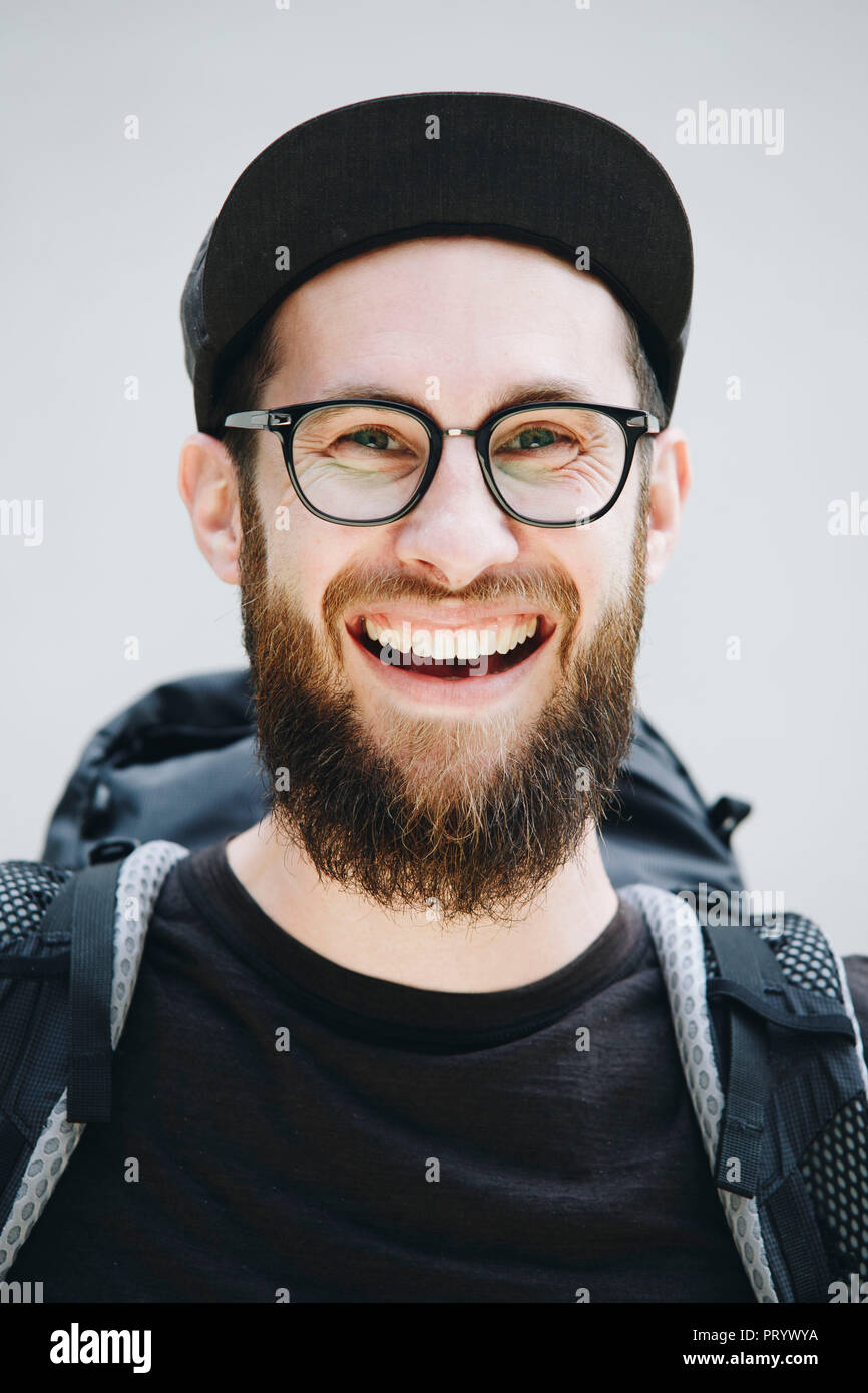 Portrait of laughing man with backpack dressed in black Stock Photo