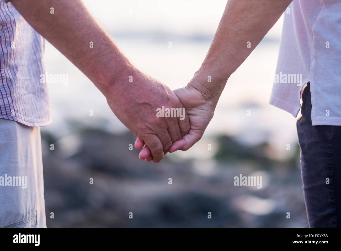 concept of vacation, tourism, travel and people - happy senior couple holding hands. Moment of relaxation and serenity with ethernal foreverness love  Stock Photo