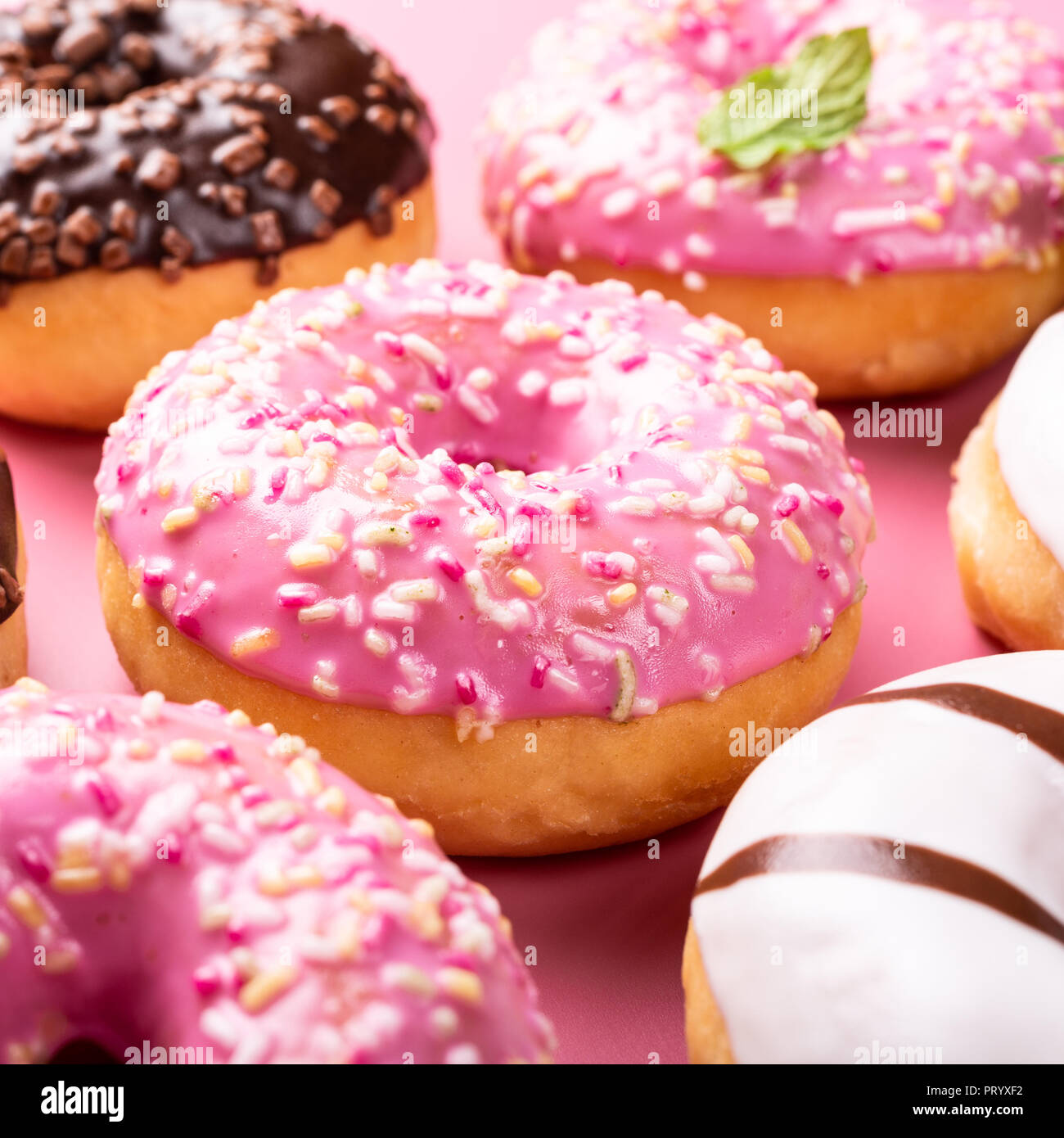 Colorful donuts on rose background Stock Photo