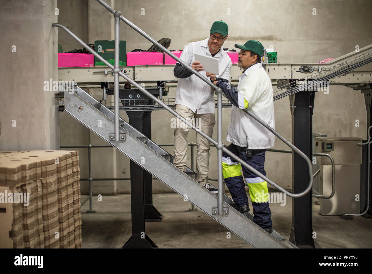 Workers having a conversation, using tablet Stock Photo