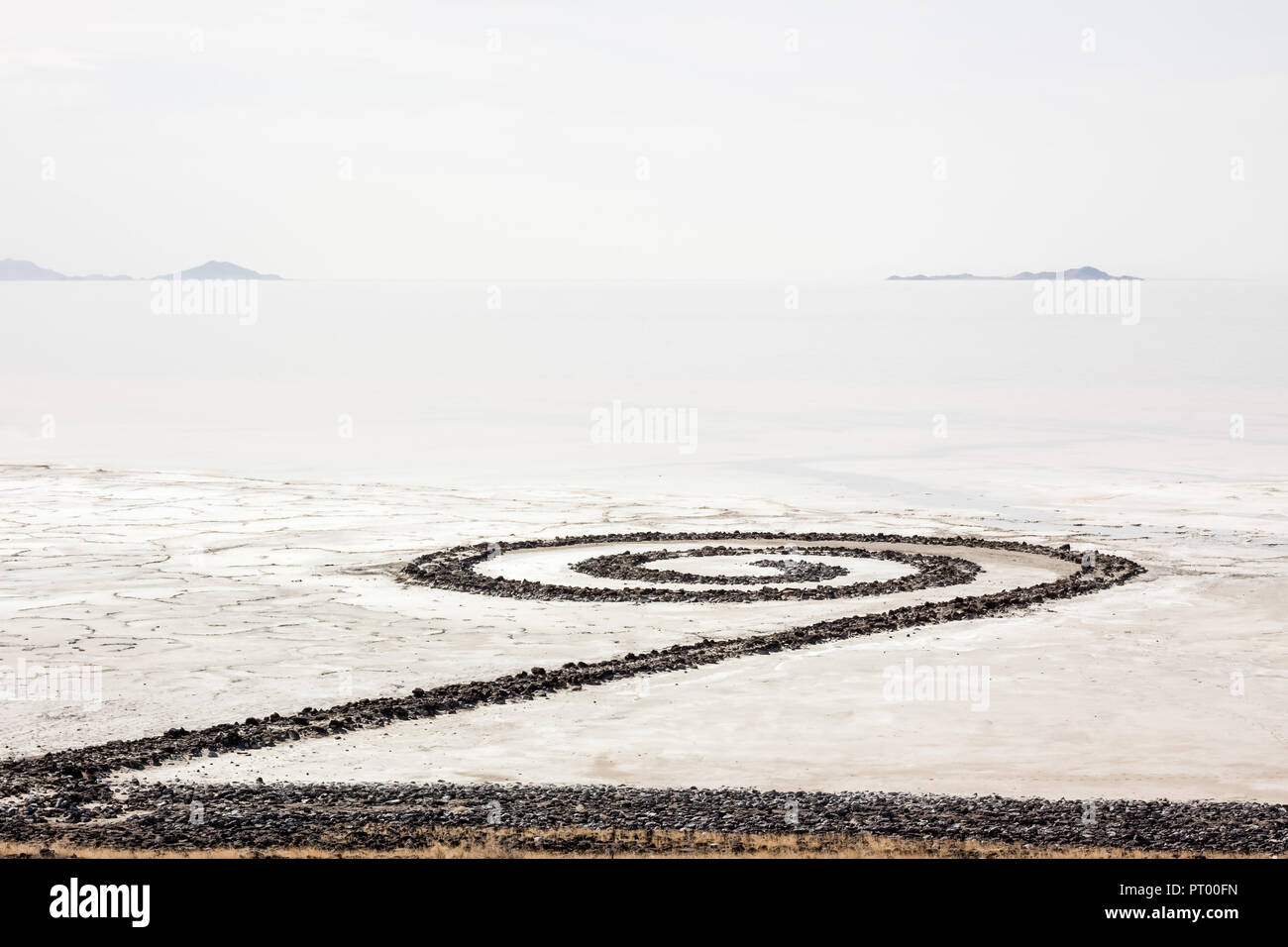 The Spiral Jetty extends into the northern end of the Great Salt Lake in Utah. Clouds overhead blend with the water of the lake in a grey layer interu Stock Photo